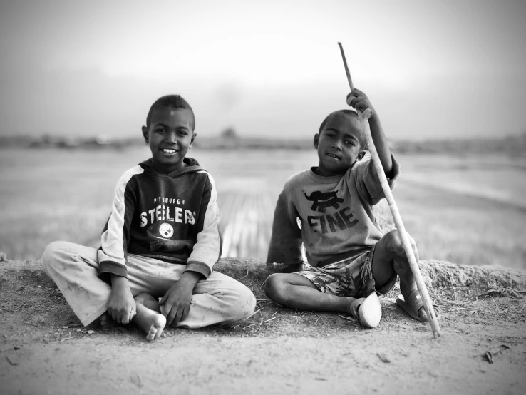 two s pose for the camera with sticks