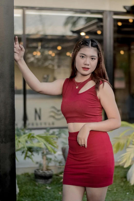 a young lady posing in a short red dress