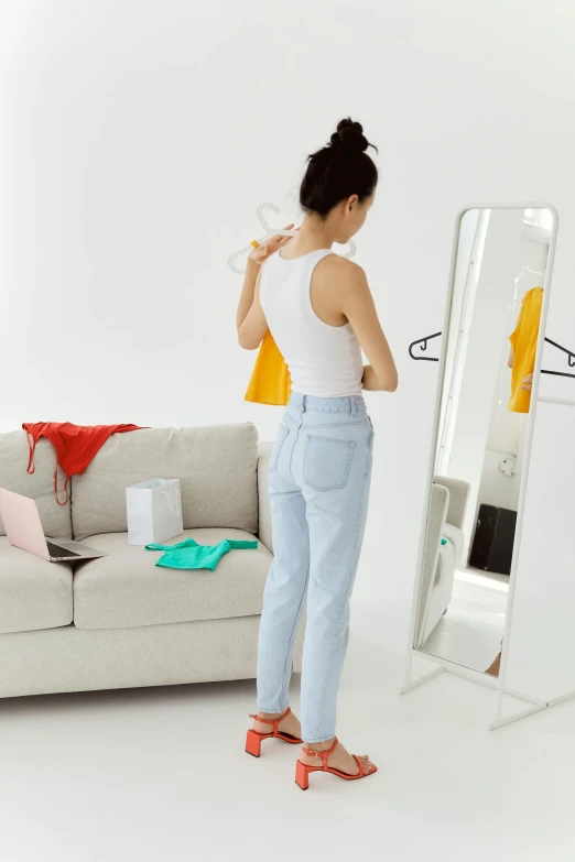 a woman is standing and looking at herself in the mirror