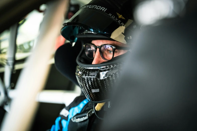 man with helmet and glasses on sitting in car