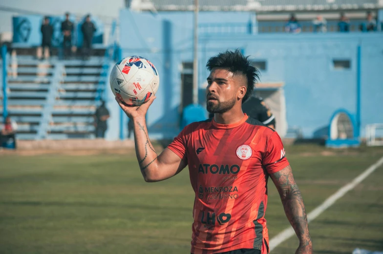 a man holds up a soccer ball in his hands