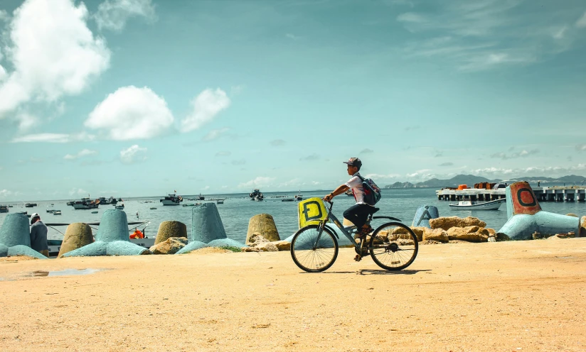 a man riding his bike along the beach