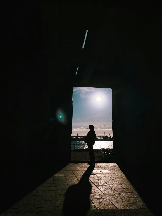 man standing in the darkness while he's on his cellphone