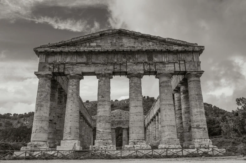 large ancient greek temple surrounded by trees and greenery