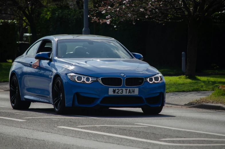 the blue bmw has a person's hand on it