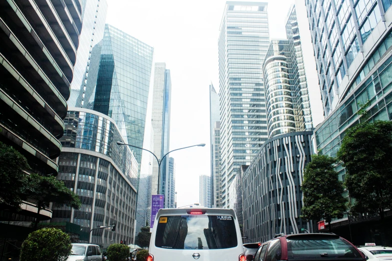 cars traveling down the street of a city in the daytime