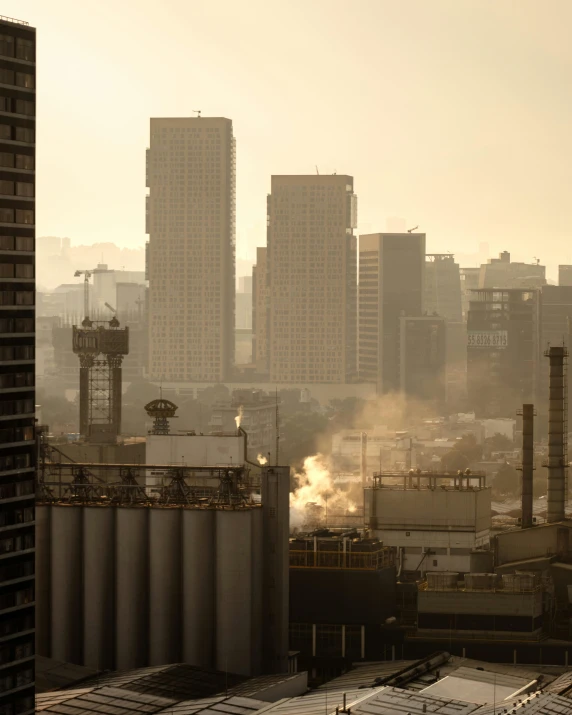 smoke pouring out of two stacks from the chimneys of a factory