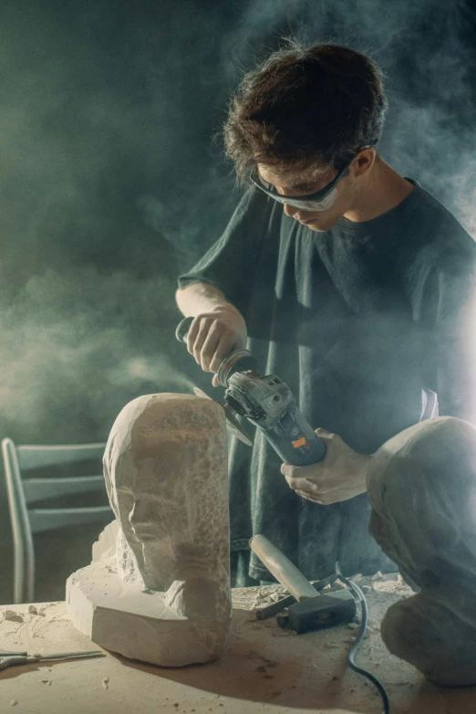 man working with a tool on a statue