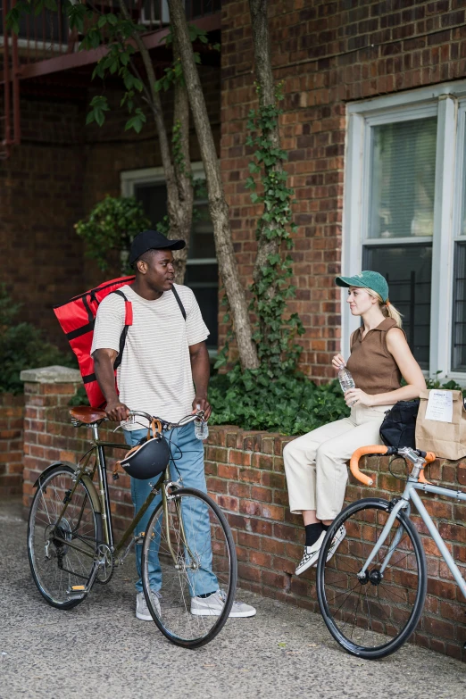 a man riding a bike next to a woman with a backpack on