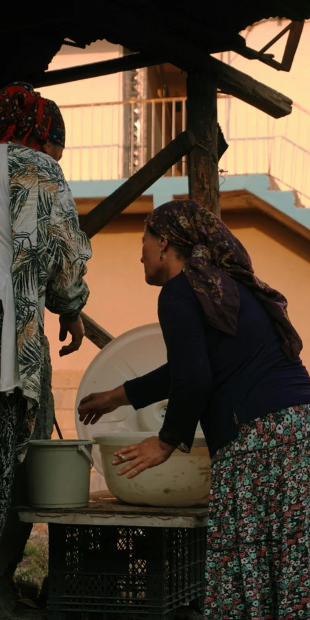 the women are preparing some drinks outside together