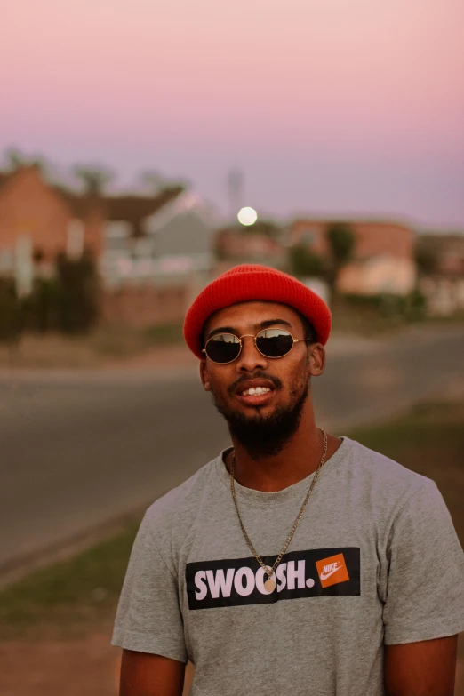 a man in a red cap and gray shirt is standing on a street