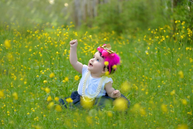 a little girl sitting in a field of wild flowers