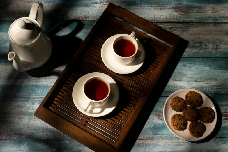 two bowls of tea and cookies sitting on a table