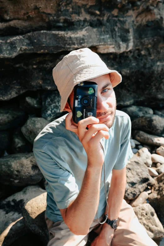 there is a male in a gray shirt and hat on the phone