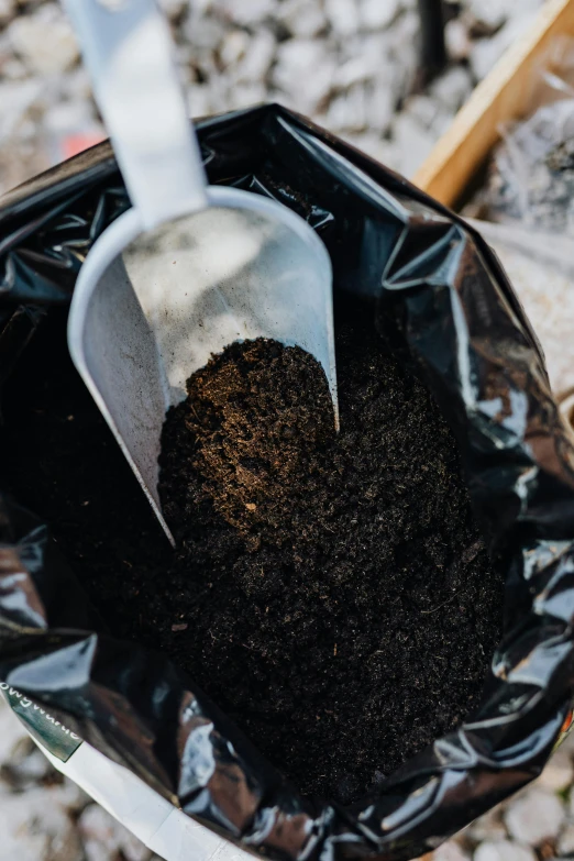 a scoop of dirt sits in a black bag