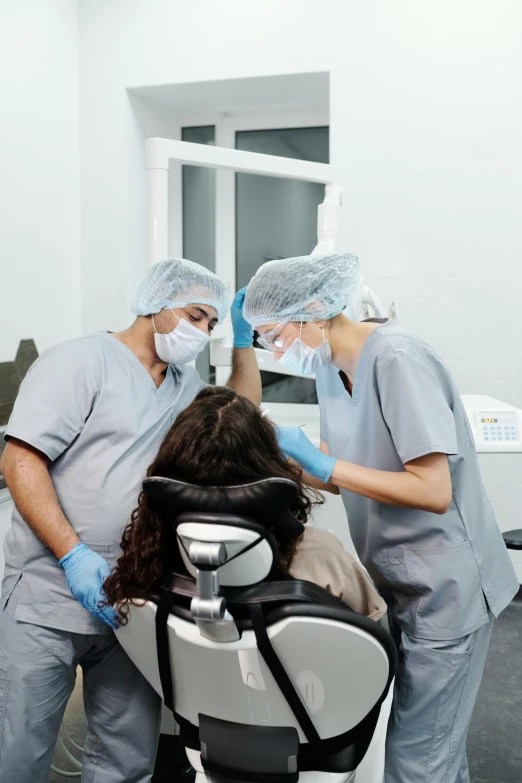 a man gets his head shaved by two doctors