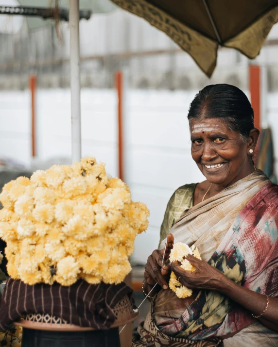 a smiling woman holding a bouquet of yellow flowers