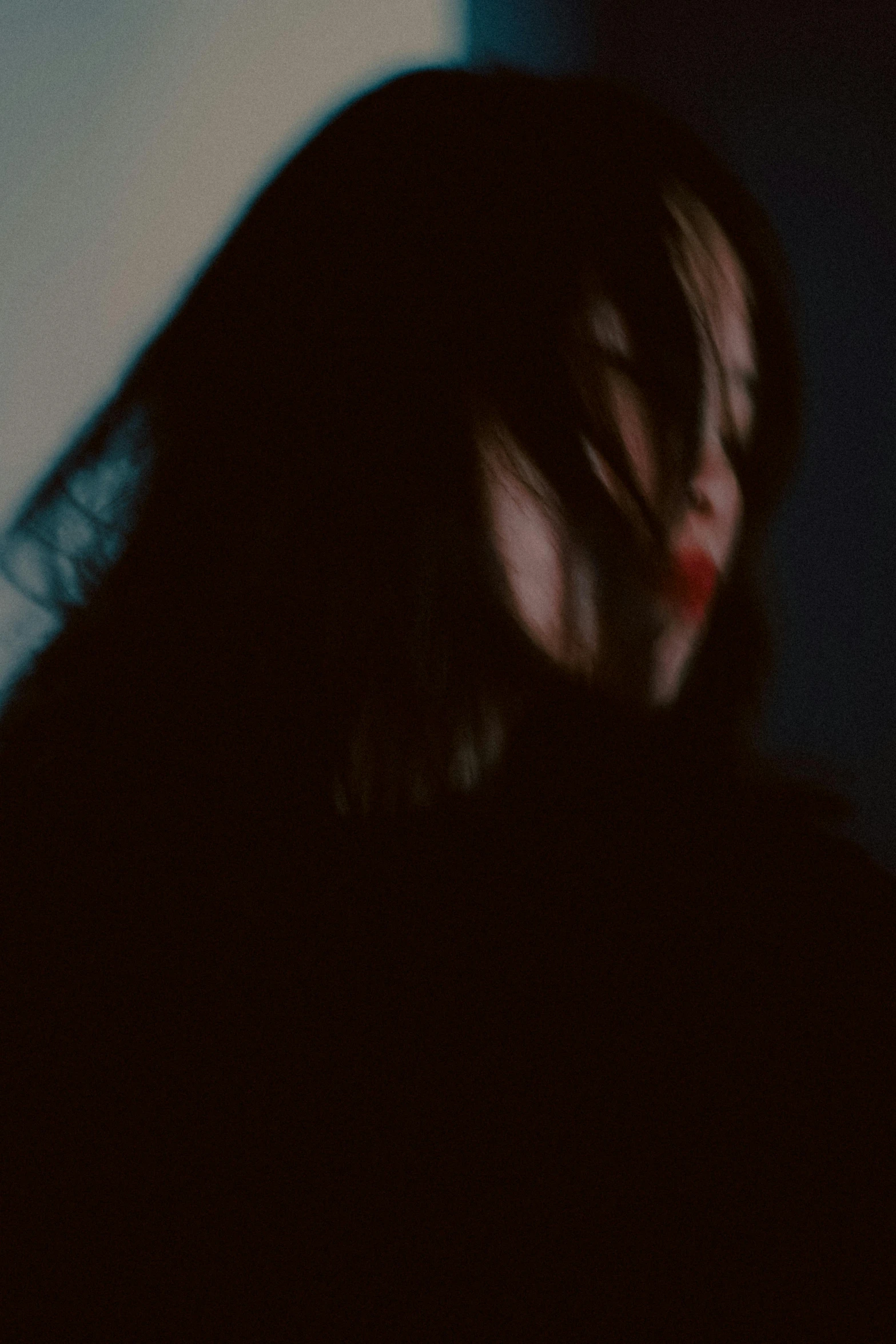 a woman looks down at her cellphone in the dark