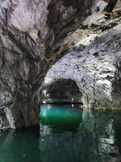 inside of an open white cave with water in the middle