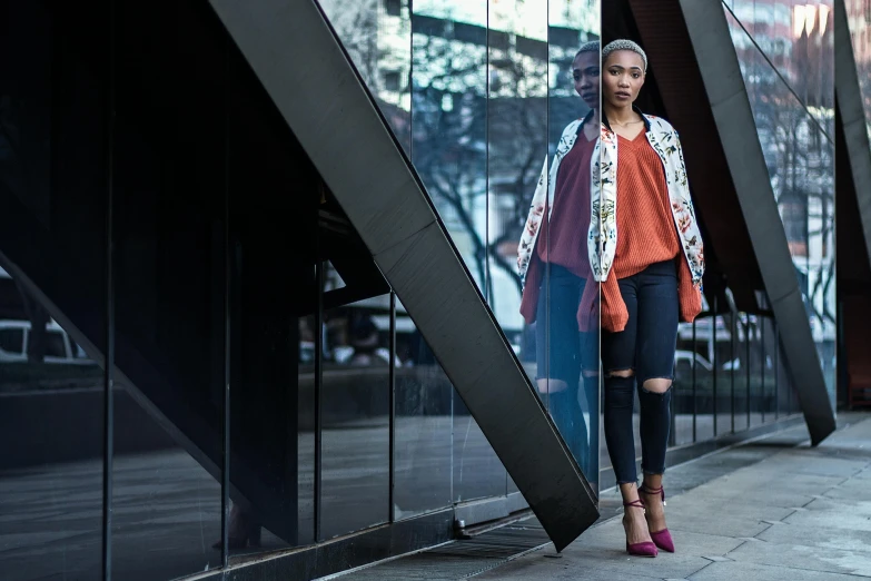 woman wearing red jacket leaning against glass wall