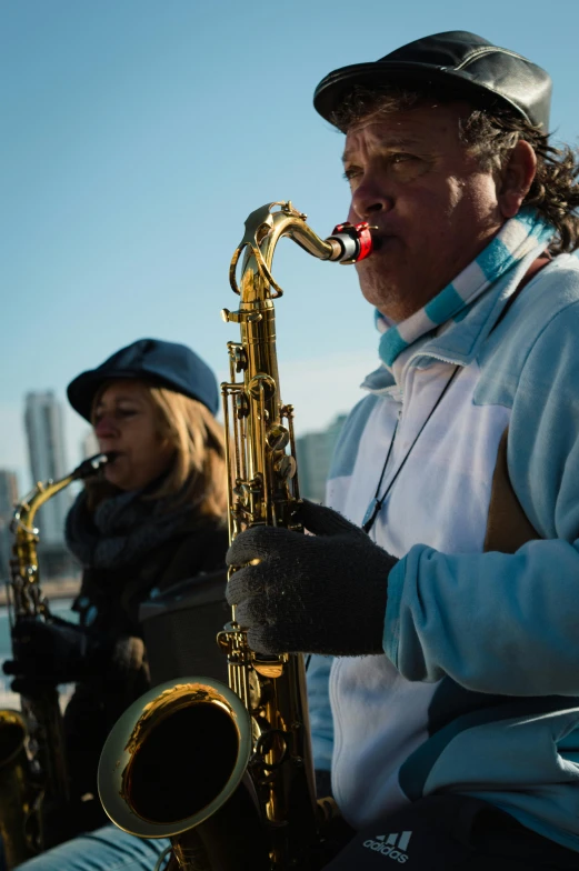 a man and woman playing saxophone next to each other