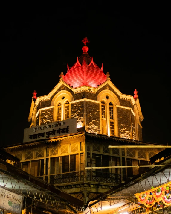 a large clock tower sitting next to a building with a lit clock on top