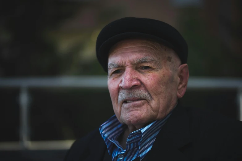 a man wearing a striped shirt and black hat