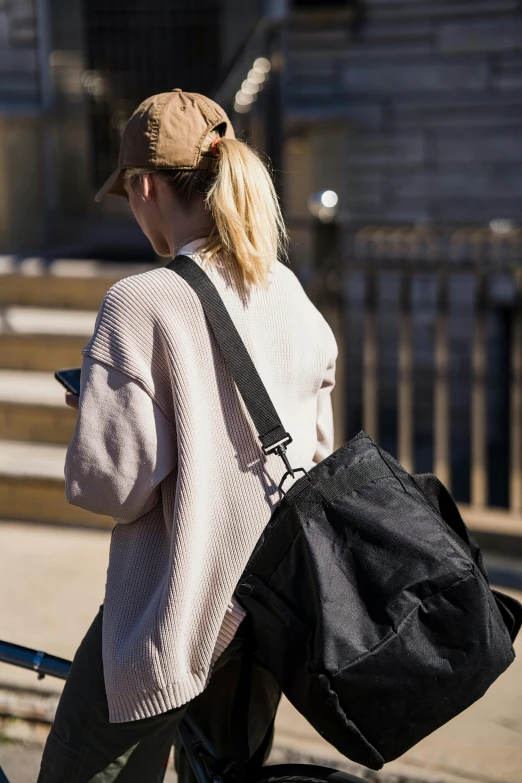 a woman walking and carrying a black backpack