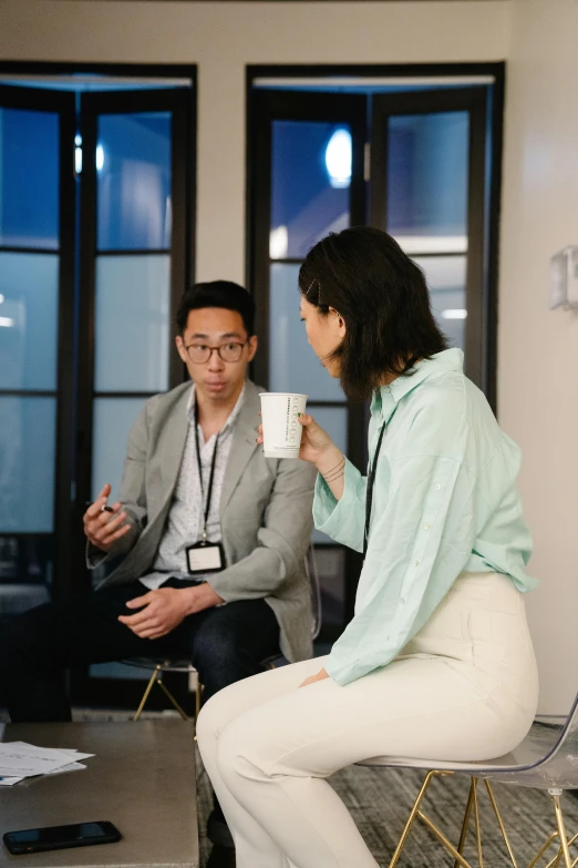 a man and woman having a conversation while sitting on chairs