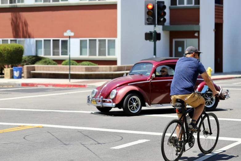 a man on a bike driving in front of a car