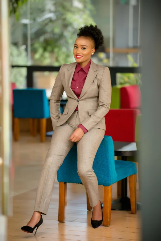 a woman wearing a business suit sitting on top of a blue chair