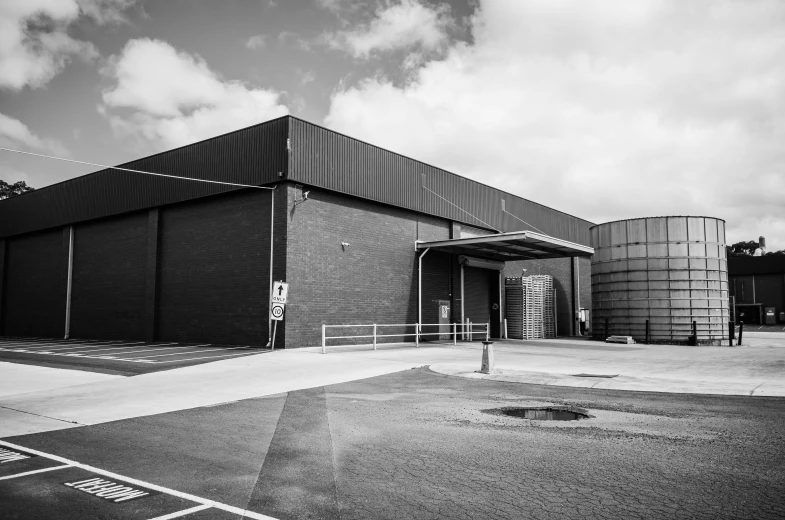 a large industrial building in a parking lot