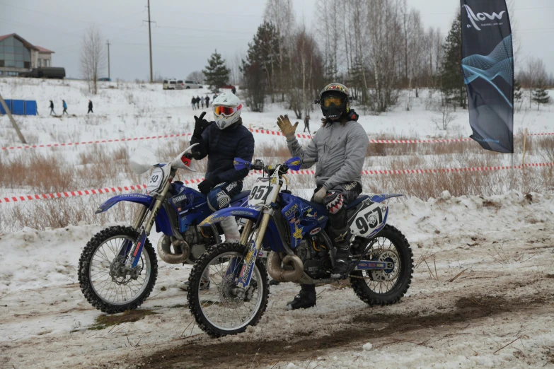 two people in full gear on a motorcycle in the snow