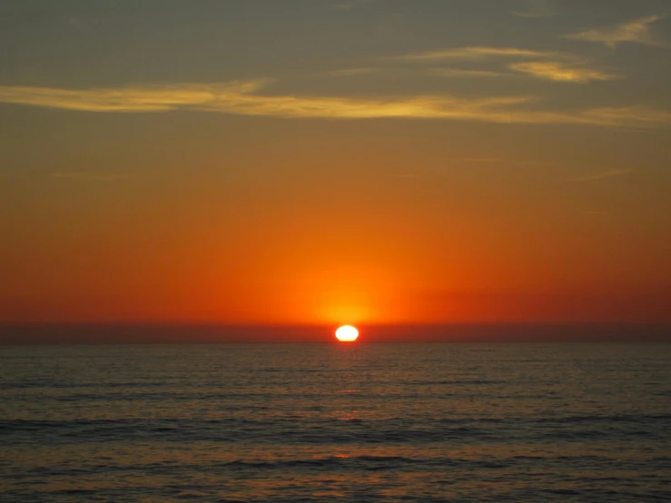 a sunset over the ocean with the sun on it's horizon