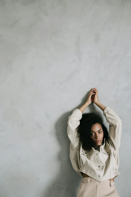 a woman standing with her hands behind her head