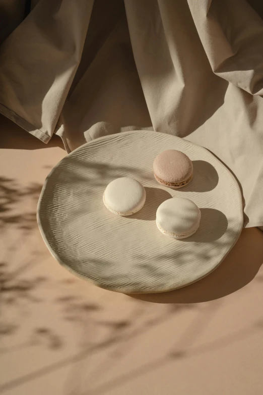 there are three macaroons sitting on a plate