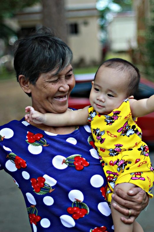 an older lady holding a child while smiling