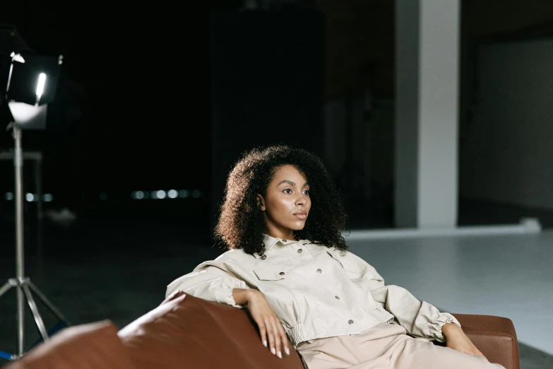 a beautiful woman sitting in a chair next to a camera