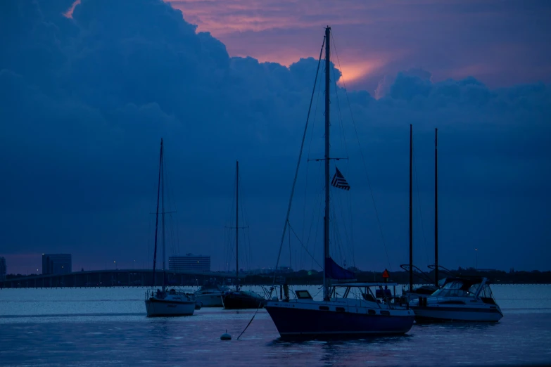 some boats sitting in the water at sunset