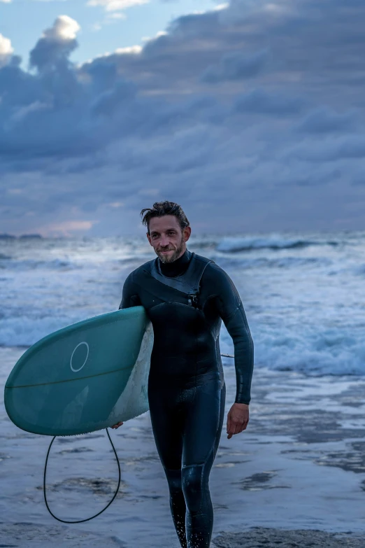 a man with a surf board standing in the water