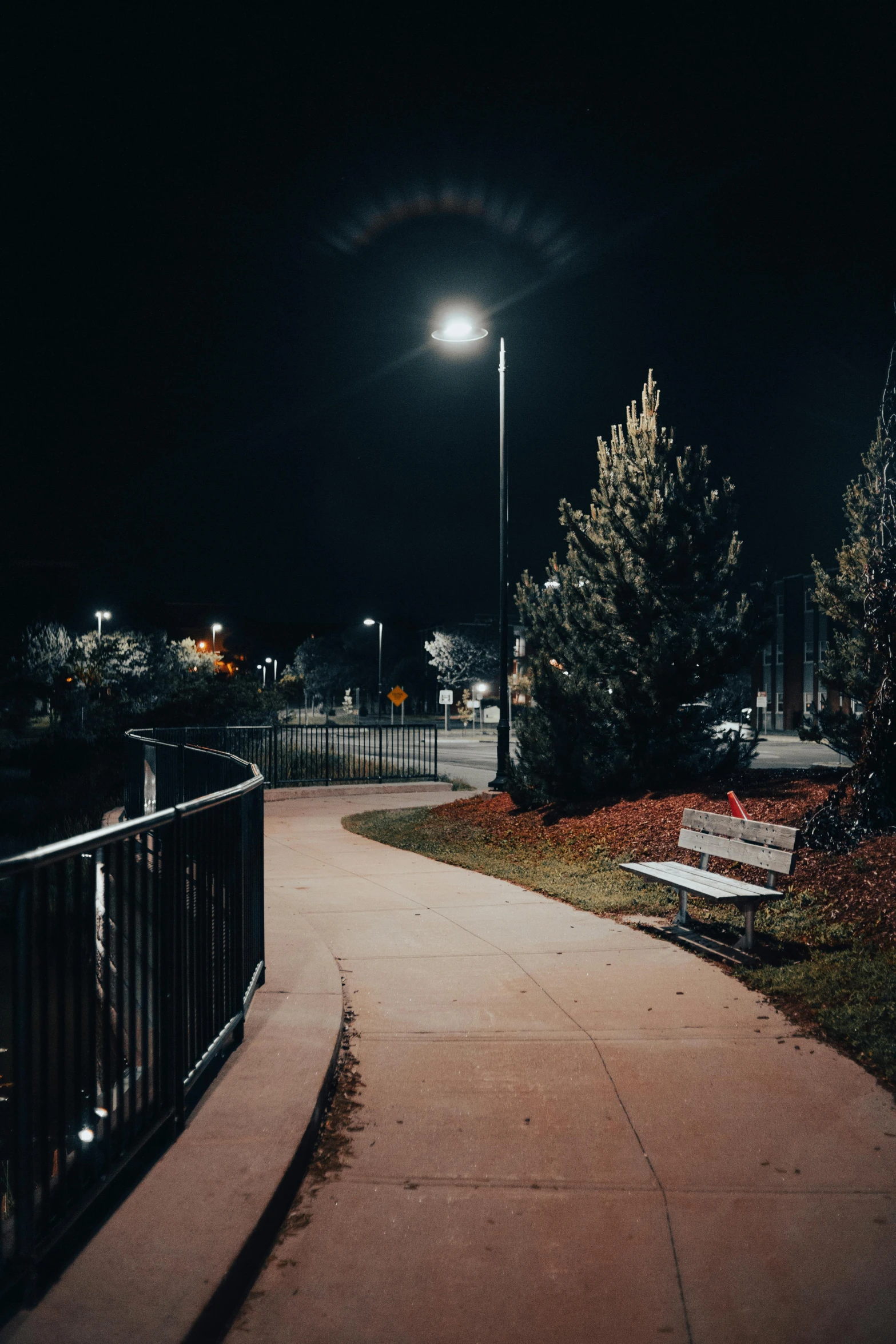 a street at night, with benches on either side