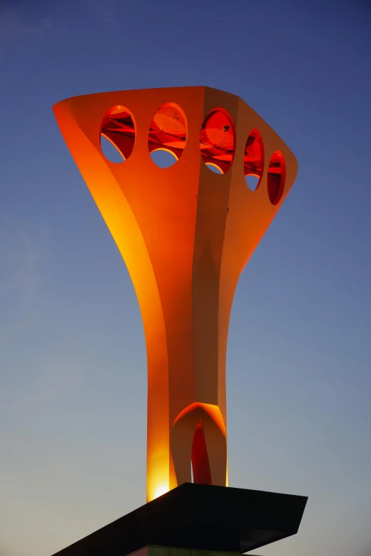 a tall neon sculpture on the side of a building