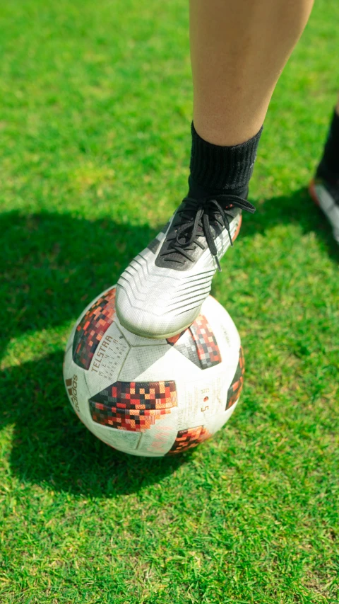 a closeup of a person wearing shoes on a soccer ball