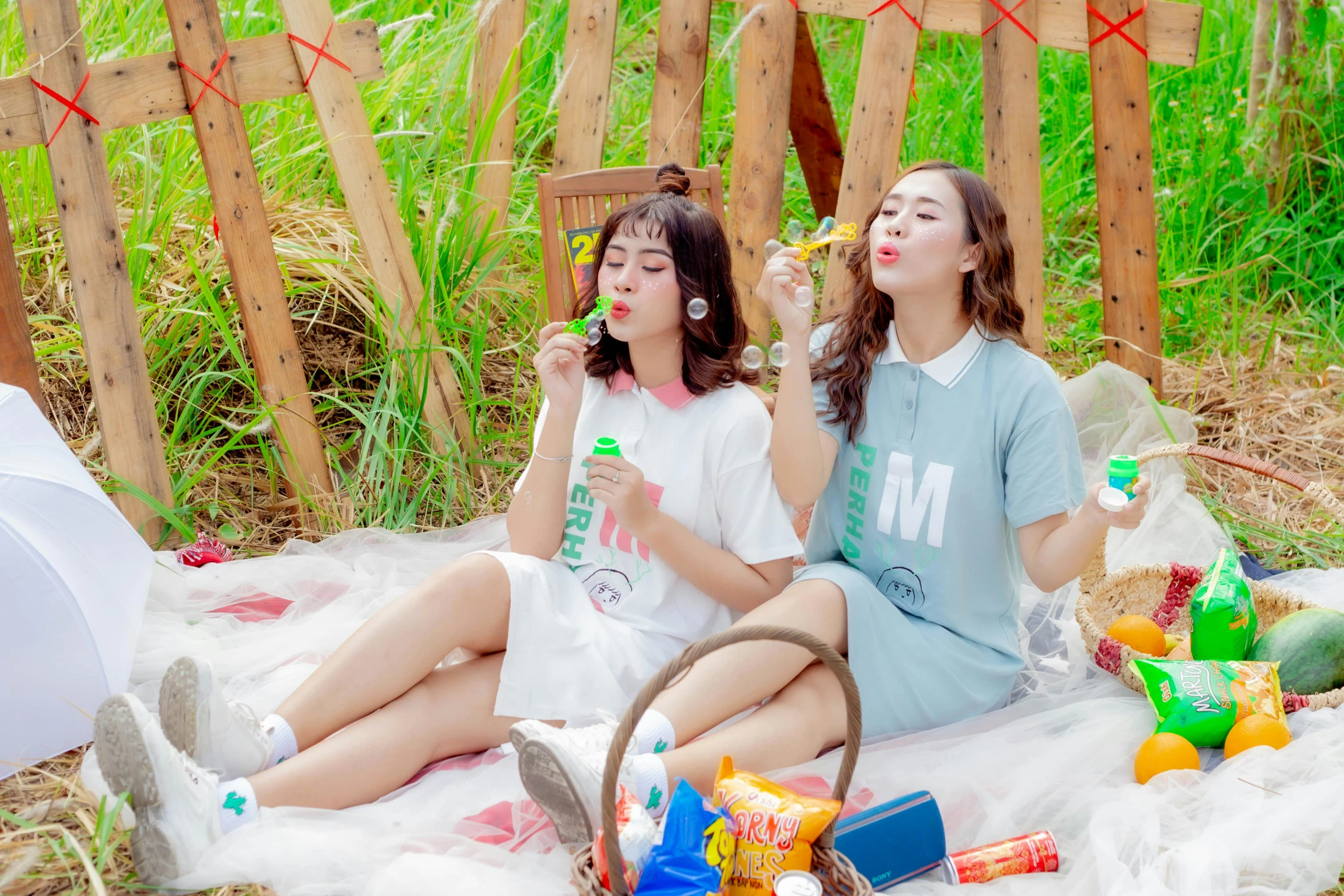 two girls sitting on the ground next to each other