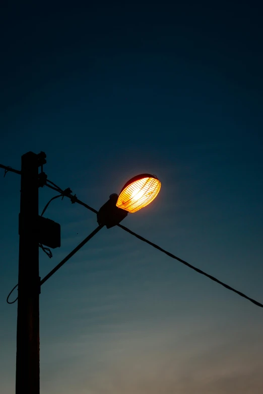 a street light with no bulbs against a dark blue sky