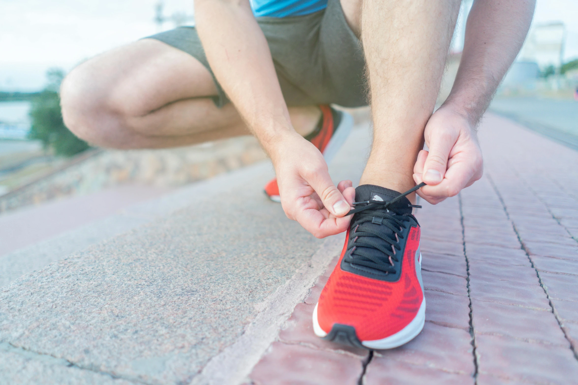 a person tying up sneakers on the ground