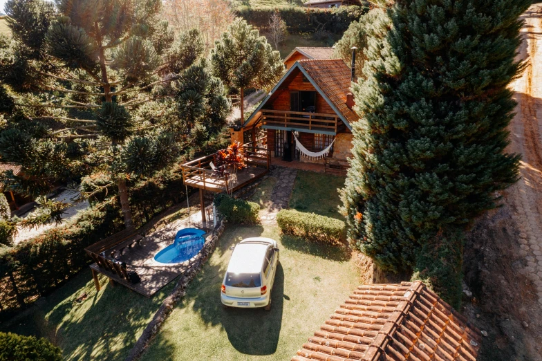 an aerial view of a house with a pool and a car