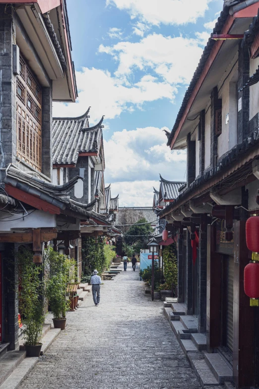 a cobblestone street leading to old asian buildings