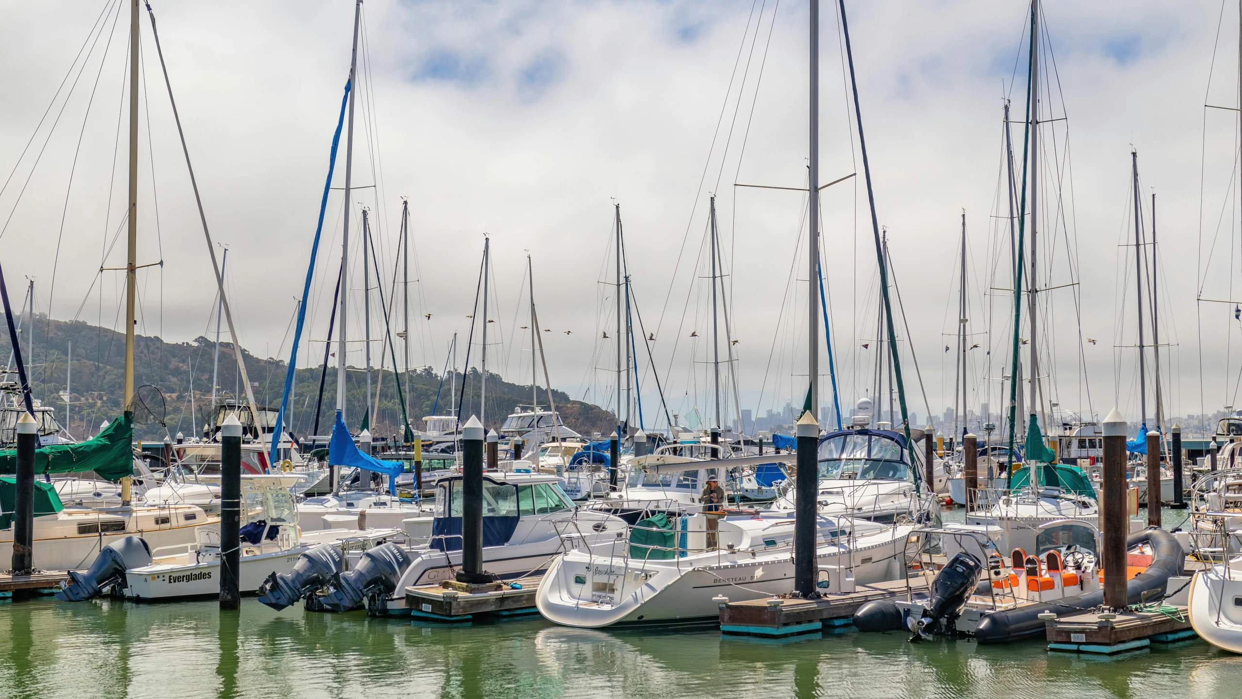 several boats are anchored at the dock in the water