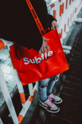 person carrying red bag with white sublife logo
